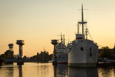 Günbatımında Kaliningrad nehir limanında gemiler var.