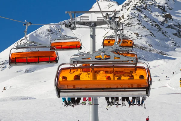 Panorama de la estación de esquí en Soelden, Tirol, Austria. Carruaje de esquí naranja brillante y esquiadores. Alpes montañas . —  Fotos de Stock