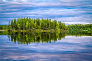 Gün batımında ve gün doğumunda Karelian gölleri. Bulutlar ve ağaçlar gölde yansıyor.