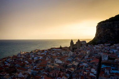 Denizden Cefalu şehrinin panoramik manzarası. Şafak vakti güneşten gelen ışık. Tyrhenian Denizi. Sicilya, İtalya
