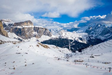 Campitello di Fassa İtalya 'da bir kayak merkezinin manzarası. Kış Dolomitleri ve bulutlu mavi gökyüzü