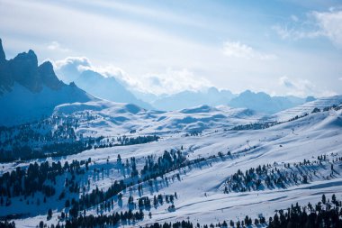 Campitello di Fassa İtalya 'da bir kayak merkezinin manzarası. Kış Dolomitleri ve bulutlu mavi gökyüzü.