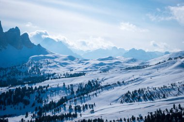 Landscape at a ski resort Campitello di Fassa Italy. Winter Dolomites and blue sky with clouds. clipart