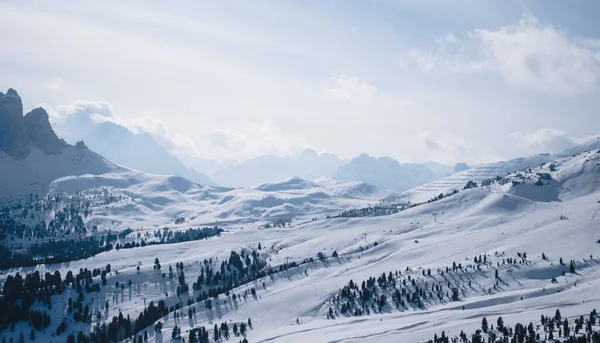 Landschaft in einem Skigebiet Campitello di Fassa Italien. Winterliche Dolomiten und blauer Himmel mit Wolken. — Stockfoto