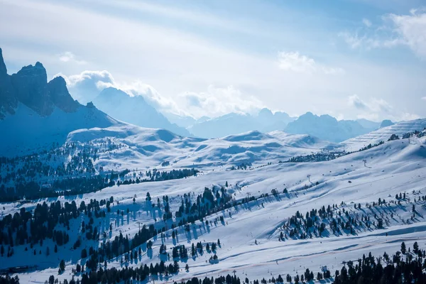 Campitello di Fassa İtalya 'da bir kayak merkezinin manzarası. Kış Dolomitleri ve bulutlu mavi gökyüzü.