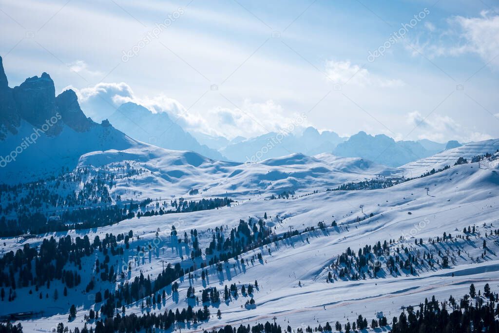 Landscape at a ski resort Campitello di Fassa Italy. Winter Dolomites and blue sky with clouds.