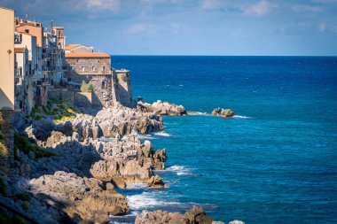 Tyrhenian Denizi 'nin kayalık kıyıları ve Sicilya kıyı şehri Cefalu' nun ortaçağ evleri