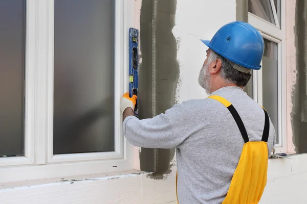 House renovation, polystyrene wall insulation, level tool — Stock Photo, Image