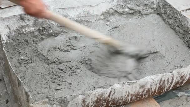 Trabajador mezclando mortero usando herramienta de azada — Vídeos de Stock