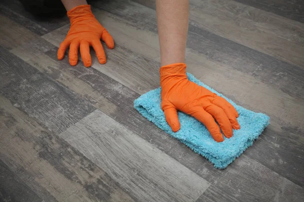 Ręka w rękawicy czyszczenie laminatu podłogi — Zdjęcie stockowe