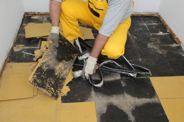 Eski vinil fayanslar bir odada ya da mutfakta yerden sökülüyor.