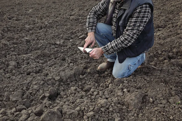 Agriculteur sur le terrain inspectant le sol — Photo