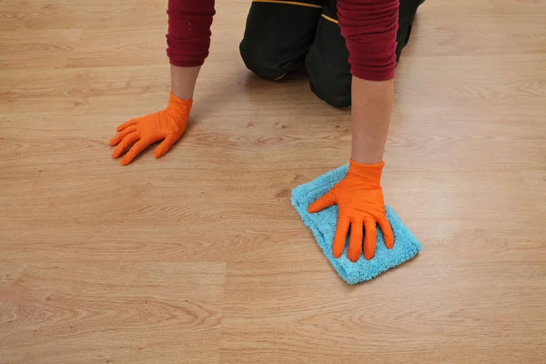 Hand in glove cleaning laminate floor — Stock Photo, Image