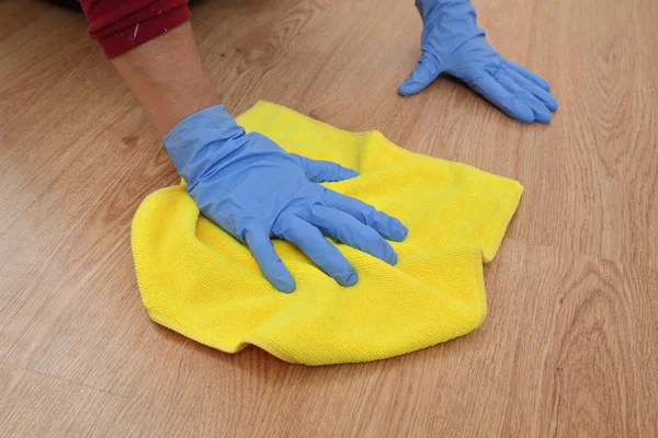 Nettoyage de sol stratifié main dans le gant — Photo