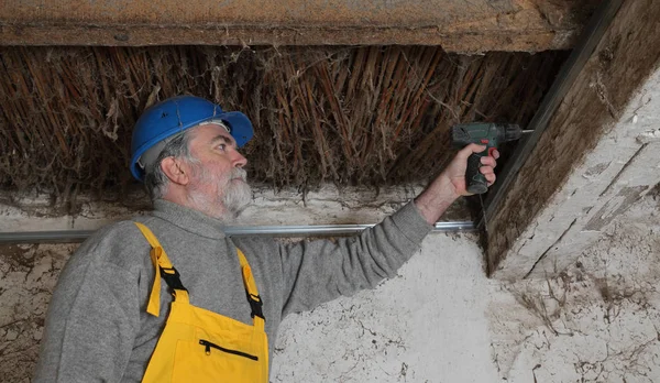 Lavoratore fissaggio stecca nel vecchio fienile, ristrutturazione — Foto Stock