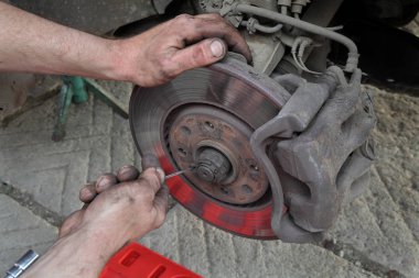 Araba tamircisi disk frenleriyle çalışır.