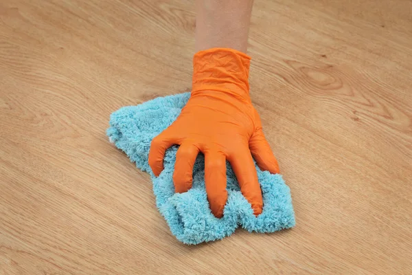 Laminate floor cleaning, closeup of hand in glove with rag