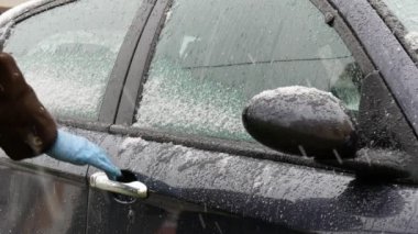 Arabanın kapısını açmak için sprey şişesinden antibakteriyel ya da temizlik solüsyonu sıkmak.