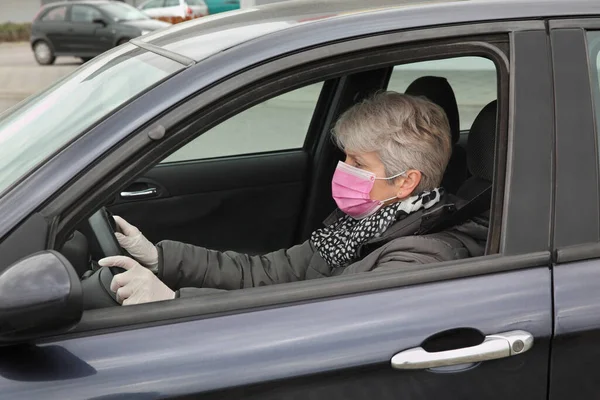 車の中に座って保護外科マスクと手袋を持つ大人の女性ドライバー コロナウイルス保護者 — ストック写真