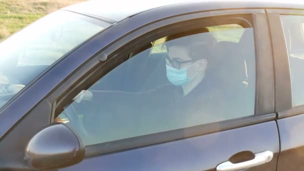 年轻司机 戴着防护口罩和手套 坐在车里 开着车窗 — 图库视频影像