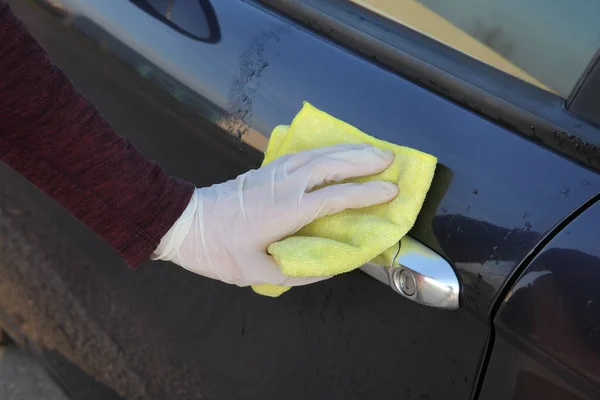 抗菌または洗浄液と布を使用して保護手袋車のドアハンドルの人間の手 — ストック写真