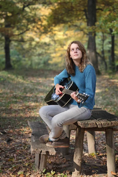リラックスした屈託のない若いですコーカサスの女の子で森の中でギター 選択的な焦点 — ストック写真