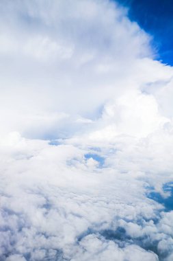 Uçak penceresinden beyaz bulutlar ve gökyüzü manzarası.