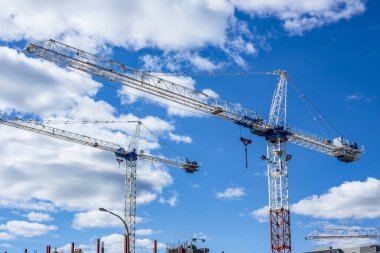 İnşaat sitesi bulutlar mavi gökyüzü üzerinde uzun boylu Vinçler