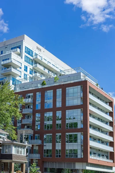 modern apartment complex in the city tree blue sky clouds