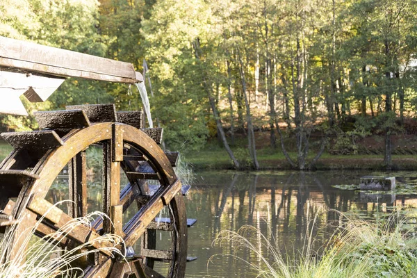 Viejo molino de agua de rueda vintage salpicaduras de agua en el estanque — Foto de Stock