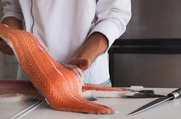 Koch hält frisches Stück Lachs in Händen — Stockfoto