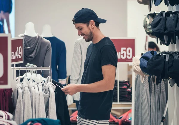 erkek gömlek alışveriş merkezinde Satılık kavramı seçme Cap gülümseyen genç 