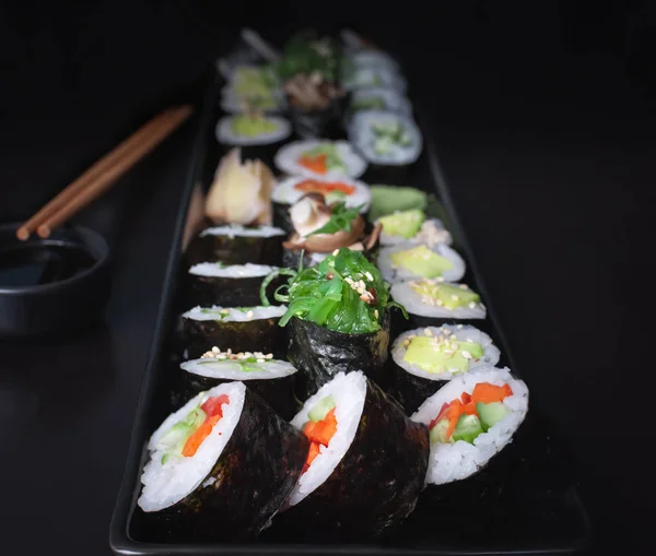 素食寿司盘 中间有蔬菜肉豆蔻 鳄梨酱和海藻根 背景是黑色的 — 图库照片