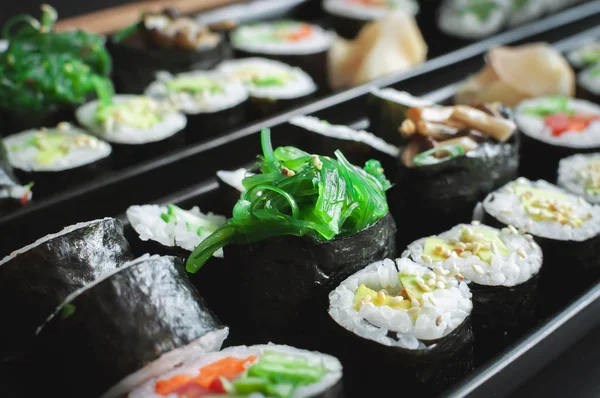 素食寿司盘 中间有鳄梨酱 凤尾鱼和海草 — 图库照片
