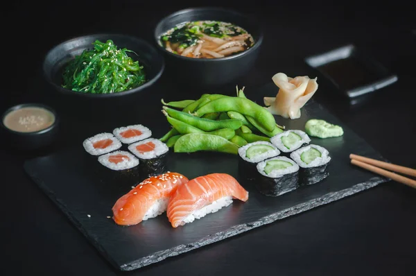健康的日本本顿午餐 搭配鲑鱼面 黄瓜面 黑鱼寿司 海藻色拉 芝麻面和黑背景的味豆腐汤 — 图库照片