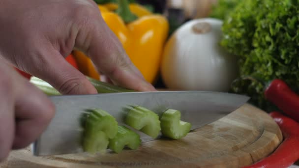 Нож режет сельдерей на мелкие кусочки — стоковое видео