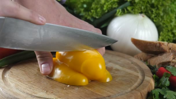 Mãos dos homens cortar o pimentão amarelo em pequenos pedaços — Vídeo de Stock