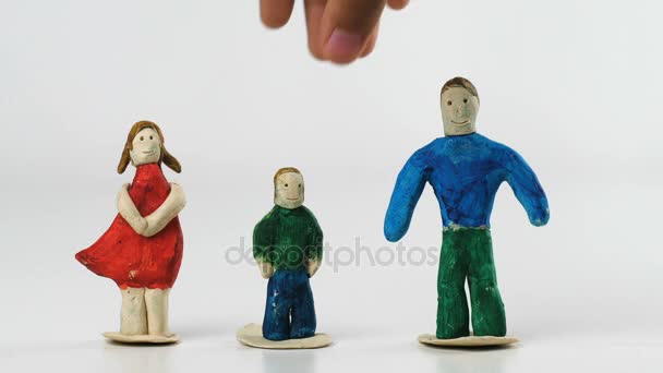 Las manos de los niños quitan la figura de plastilina del niño de la mesa — Vídeos de Stock