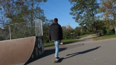 Patenci kaykay ile bir kutu üzerinde elinde, arka yan görünüm rides.