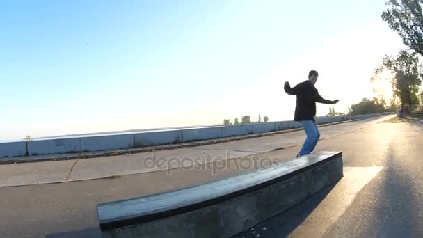 Junger Mann rutscht auf Skateboard am Sims entlang, Sonnenaufgang am Morgen — Stockvideo