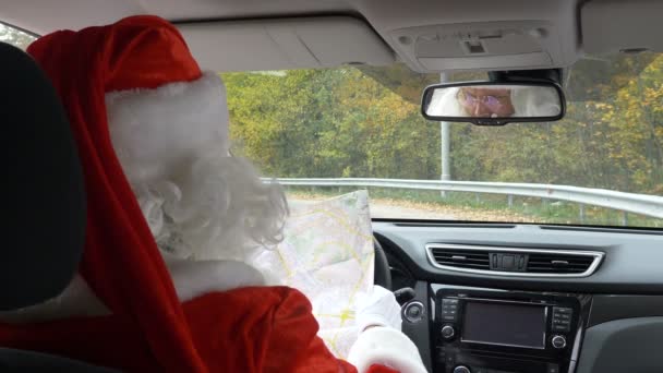 Santa Claus förlorat sin väg och tittar på kartan tillbaka Visa 50 fps — Stockvideo