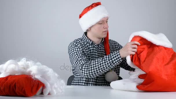 Joven en un sombrero de santa mira a una chaqueta de Santa Claus 50 fps — Vídeos de Stock