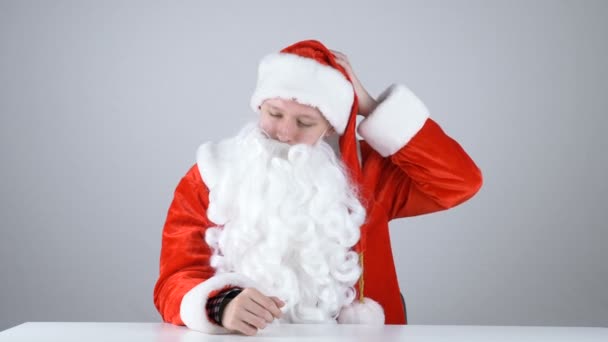 一个年轻的家伙在圣诞老人的服装脱掉他的帽子 50 fps — 图库视频影像