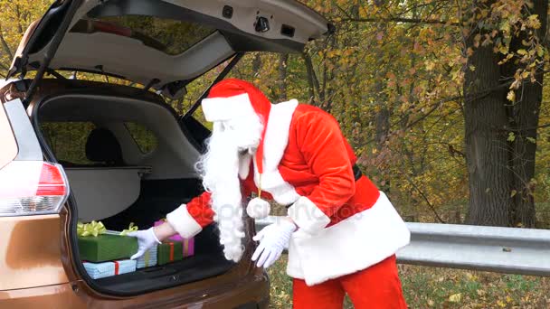 Santa Claus pone regalos en el maletero de un coche 50 fps — Vídeos de Stock