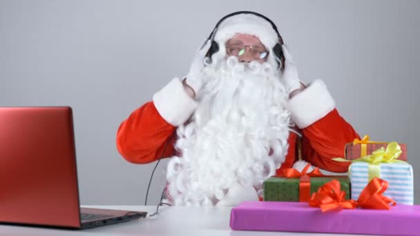 Santa claus lyssnar på musik i hörlurar och dansar 50 fps — Stockvideo
