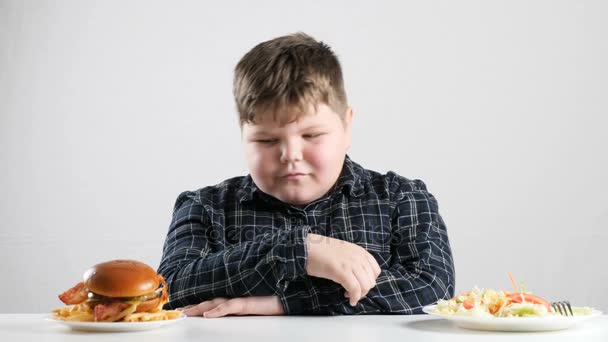 Young fat boy chooses a burger 50 fps — Stock Video