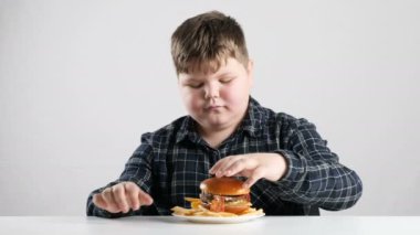 Genç şişman çocuk ekler patates hamburger için 50 fps