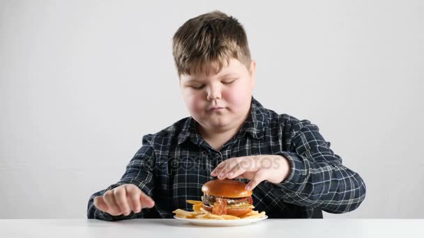 Młody chłopak tłuszczu dodaje frytki do burger 50 fps — Wideo stockowe