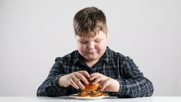 Vet jongen eet een hamburger 50 fps — Stockvideo