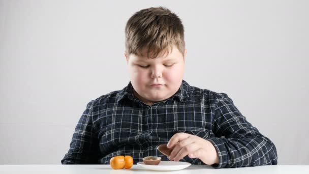 Unga fet pojke äter en choklad ägg 50 fps — Stockvideo